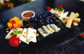 cheese plate with cheddar cubes, white cheese, parmesan sticks, blue cheese and grapes 1